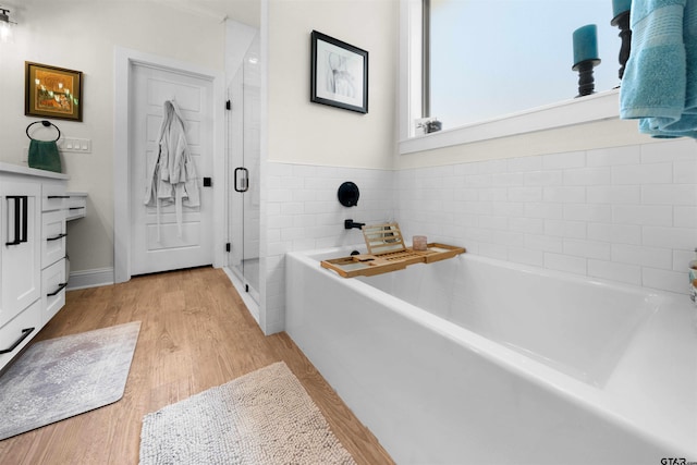 bathroom featuring independent shower and bath, vanity, and wood-type flooring