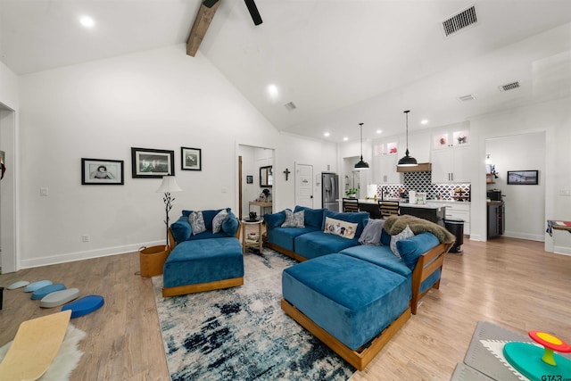 living room with beam ceiling, high vaulted ceiling, light hardwood / wood-style flooring, and ceiling fan