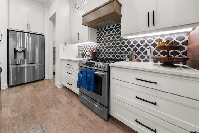 kitchen featuring tasteful backsplash, white cabinets, custom exhaust hood, and appliances with stainless steel finishes