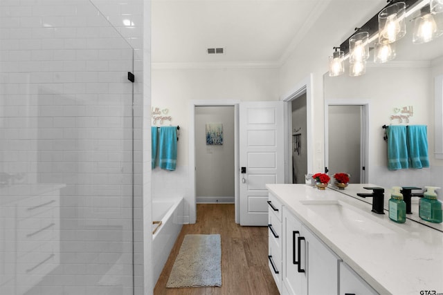 bathroom featuring hardwood / wood-style flooring, vanity, separate shower and tub, and ornamental molding