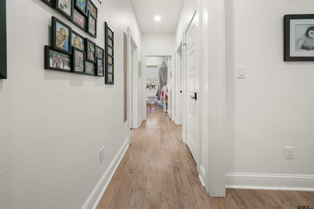 corridor with hardwood / wood-style flooring