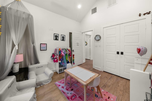 interior space with hardwood / wood-style floors and high vaulted ceiling