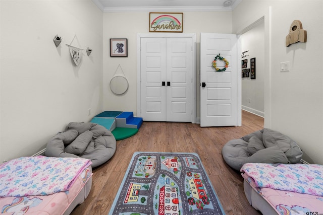 bedroom with crown molding, a closet, and hardwood / wood-style floors