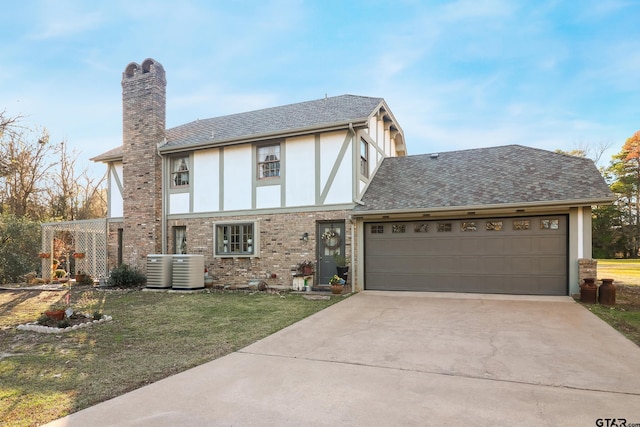 tudor house with cooling unit, a garage, and a front yard