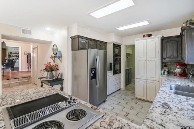 kitchen with light stone countertops, dark brown cabinets, sink, and black appliances