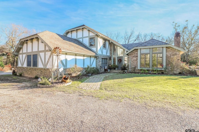 tudor home featuring a front lawn