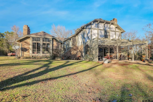 back of property featuring a patio, a yard, and a pergola