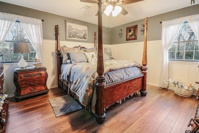 bedroom featuring multiple windows, hardwood / wood-style flooring, and ceiling fan