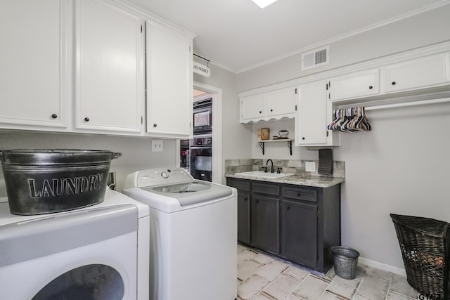 washroom with cabinets, ornamental molding, separate washer and dryer, and sink