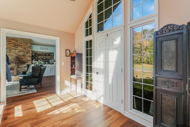 entryway with lofted ceiling and light wood-type flooring