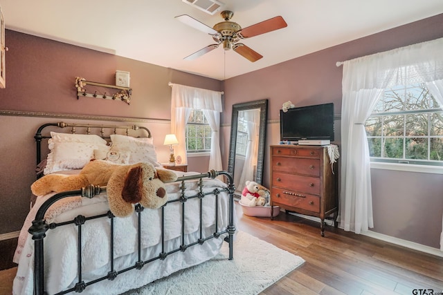 bedroom featuring multiple windows, ceiling fan, and light hardwood / wood-style floors