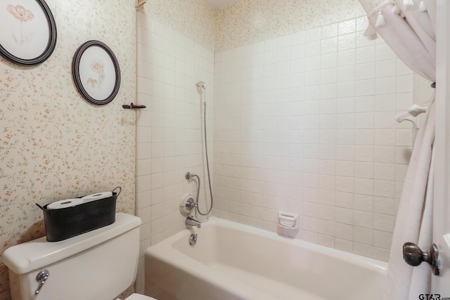 bathroom with tiled shower / bath combo and toilet