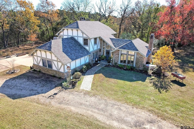 tudor home with a front lawn