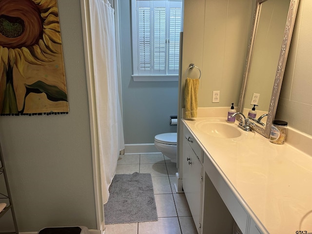 bathroom with toilet, vanity, and tile patterned floors