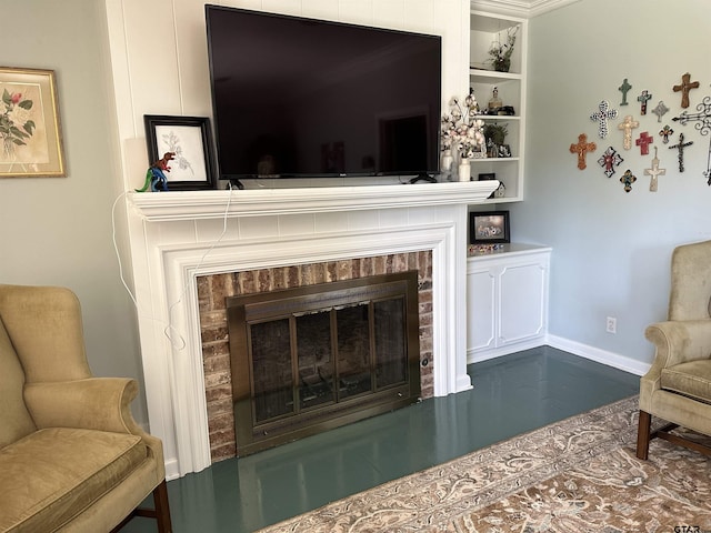 sitting room with built in shelves, ornamental molding, and a fireplace