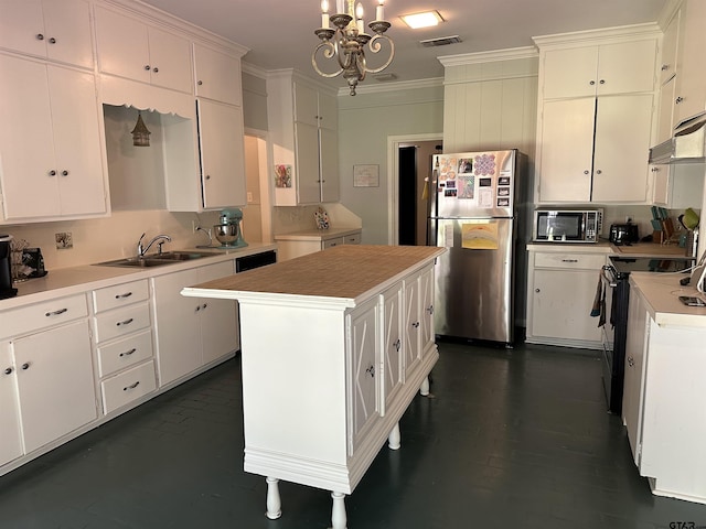 kitchen featuring stainless steel refrigerator, a kitchen island, white cabinetry, and electric range oven