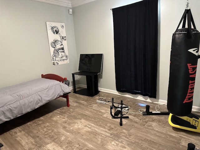 bedroom featuring ornamental molding and light hardwood / wood-style flooring