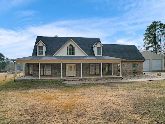 farmhouse-style home featuring a garage, an outdoor structure, covered porch, and a front lawn