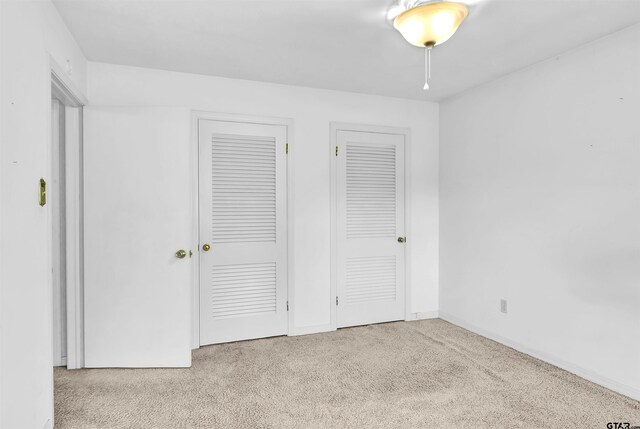 507 Tullie Dr, Longview, TX 75601 - unfurnished bedroom featuring carpet flooring, multiple closets, and baseboards