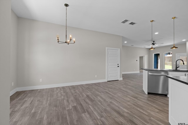 kitchen with stainless steel dishwasher, sink, decorative light fixtures, light wood-type flooring, and ceiling fan with notable chandelier