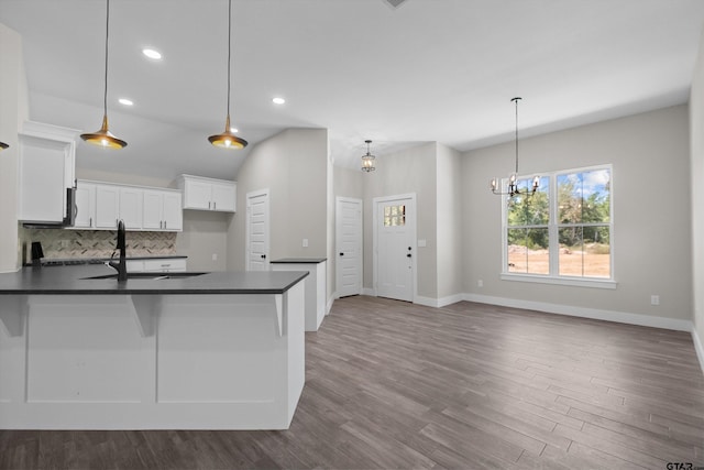 kitchen with sink, decorative light fixtures, white cabinetry, and tasteful backsplash