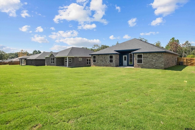 rear view of house featuring a lawn