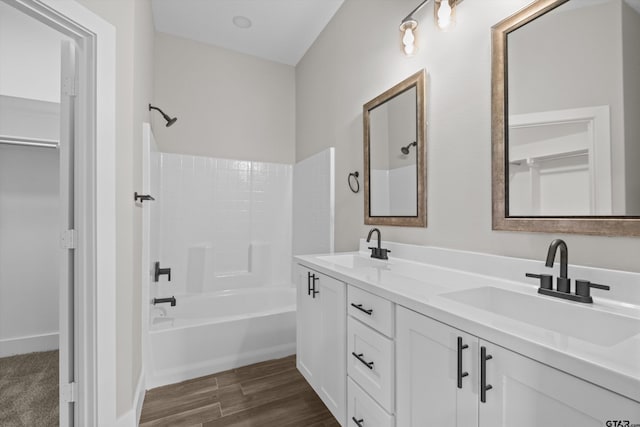 bathroom featuring hardwood / wood-style flooring, washtub / shower combination, and vanity