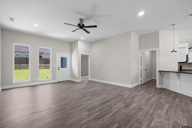 unfurnished living room with hardwood / wood-style flooring and ceiling fan