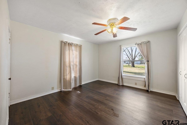 spare room with ceiling fan, dark wood-type flooring, and a textured ceiling