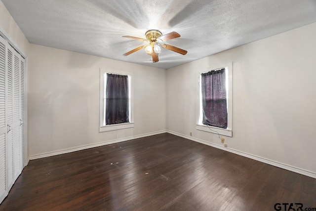 interior space with ceiling fan, dark hardwood / wood-style flooring, and a textured ceiling