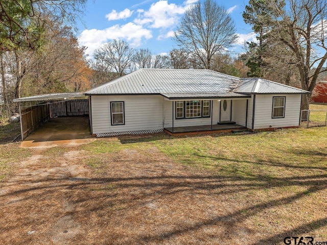 rear view of house featuring a carport, a yard, and covered porch