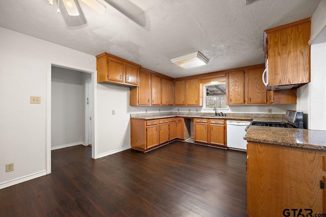 kitchen with sink, dark stone countertops, white dishwasher, dark wood-type flooring, and stainless steel range with gas stovetop