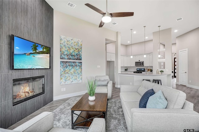 living room featuring ceiling fan and light hardwood / wood-style floors