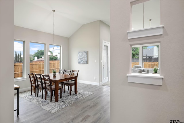 dining area with light wood-type flooring, lofted ceiling, and a wealth of natural light