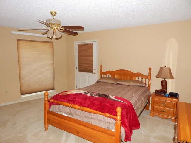 carpeted bedroom featuring a textured ceiling and ceiling fan