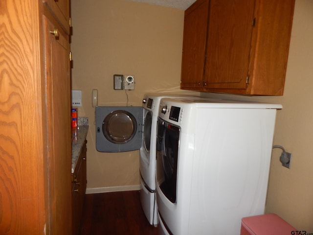 laundry room featuring washer and clothes dryer, cabinets, and dark hardwood / wood-style floors