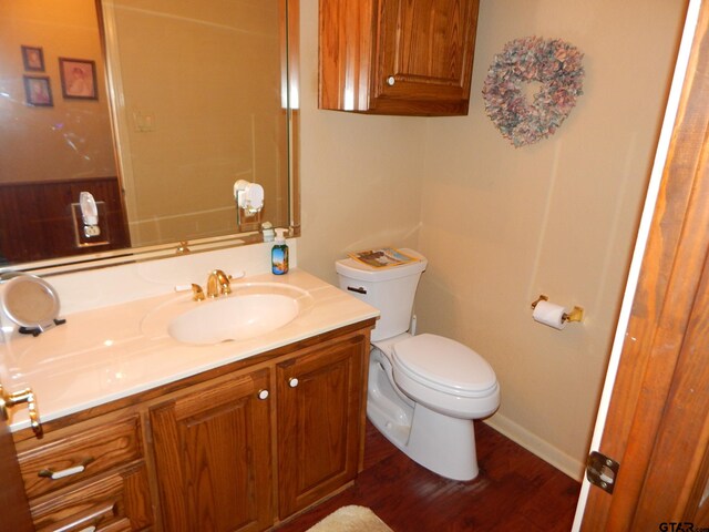 3073 E Lake Lake, Gladewater, TX 75647 - bathroom featuring vanity, toilet, wood finished floors, and baseboards