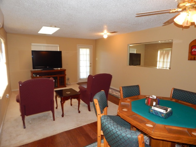 dining space with hardwood / wood-style flooring, ceiling fan, and a textured ceiling