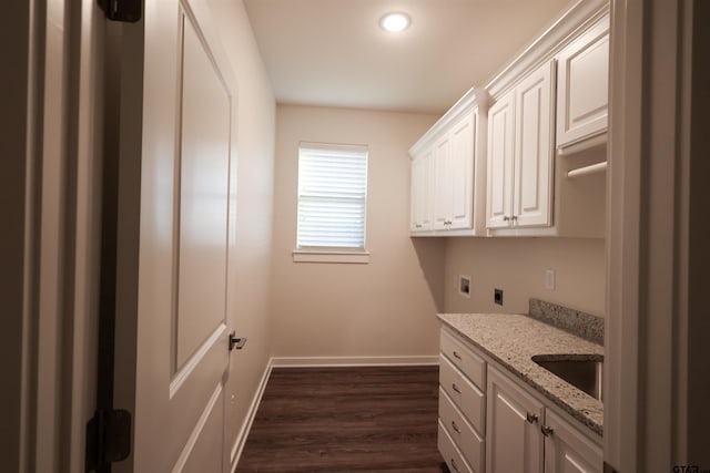 clothes washing area with dark hardwood / wood-style flooring, electric dryer hookup, cabinets, sink, and washer hookup