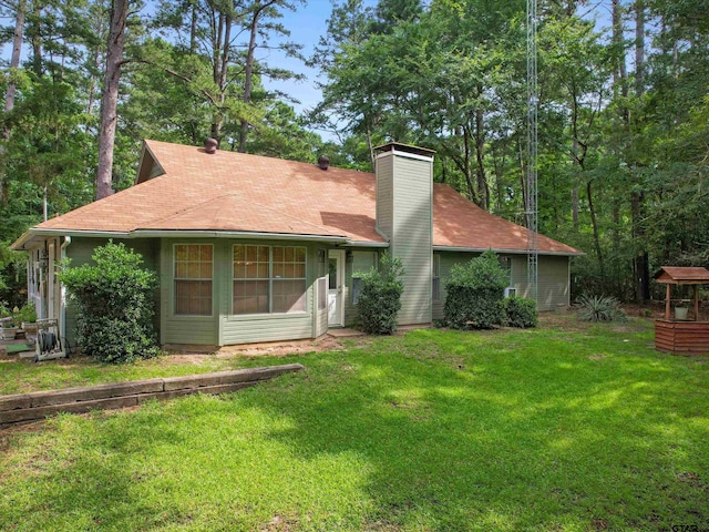184 Shiprock Path, Holly Lake Ranch, TX 75765 - back of house featuring a chimney and a yard