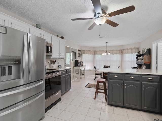 184 Shiprock Path, Holly Lake Ranch, TX 75765 - kitchen with appliances with stainless steel finishes, a ceiling fan, light tile patterned flooring, light countertops, and a textured ceiling