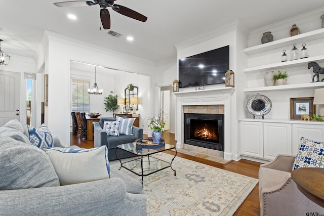 16050 Stonebriar Ct, Lindale, TX 75771 - living room with crown molding, a ceiling fan, a chandelier, a fireplace, and wood finished floors