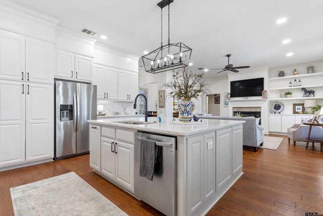 16050 Stonebriar Ct, Lindale, TX 75771 - kitchen featuring appliances with stainless steel finishes, ceiling fan, recessed lighting, a tile fireplace, and a kitchen island with sink