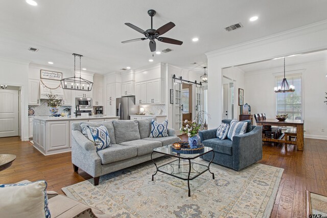 16050 Stonebriar Ct, Lindale, TX 75771 - living room with a chandelier, a ceiling fan, crown molding, a barn door, and recessed lighting