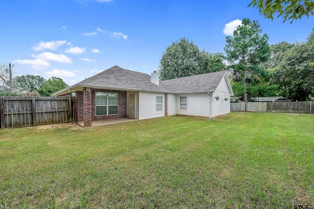 back of property with a patio area and a yard