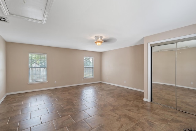 unfurnished bedroom featuring tile patterned floors, multiple windows, ceiling fan, and a closet