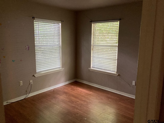 spare room with hardwood / wood-style floors and plenty of natural light