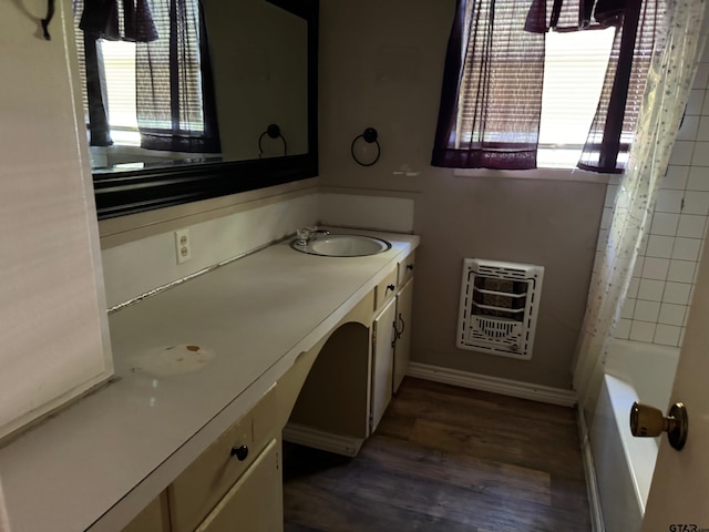 bathroom with wood-type flooring, plenty of natural light, heating unit, and shower / tub combo with curtain