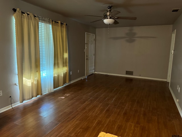 spare room with dark wood-type flooring and ceiling fan