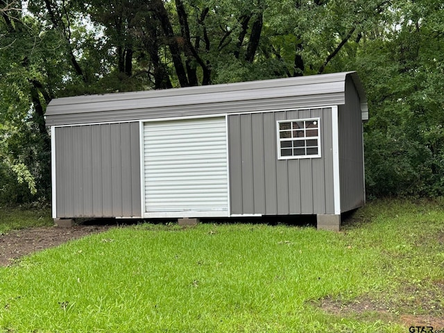 view of outbuilding featuring a lawn